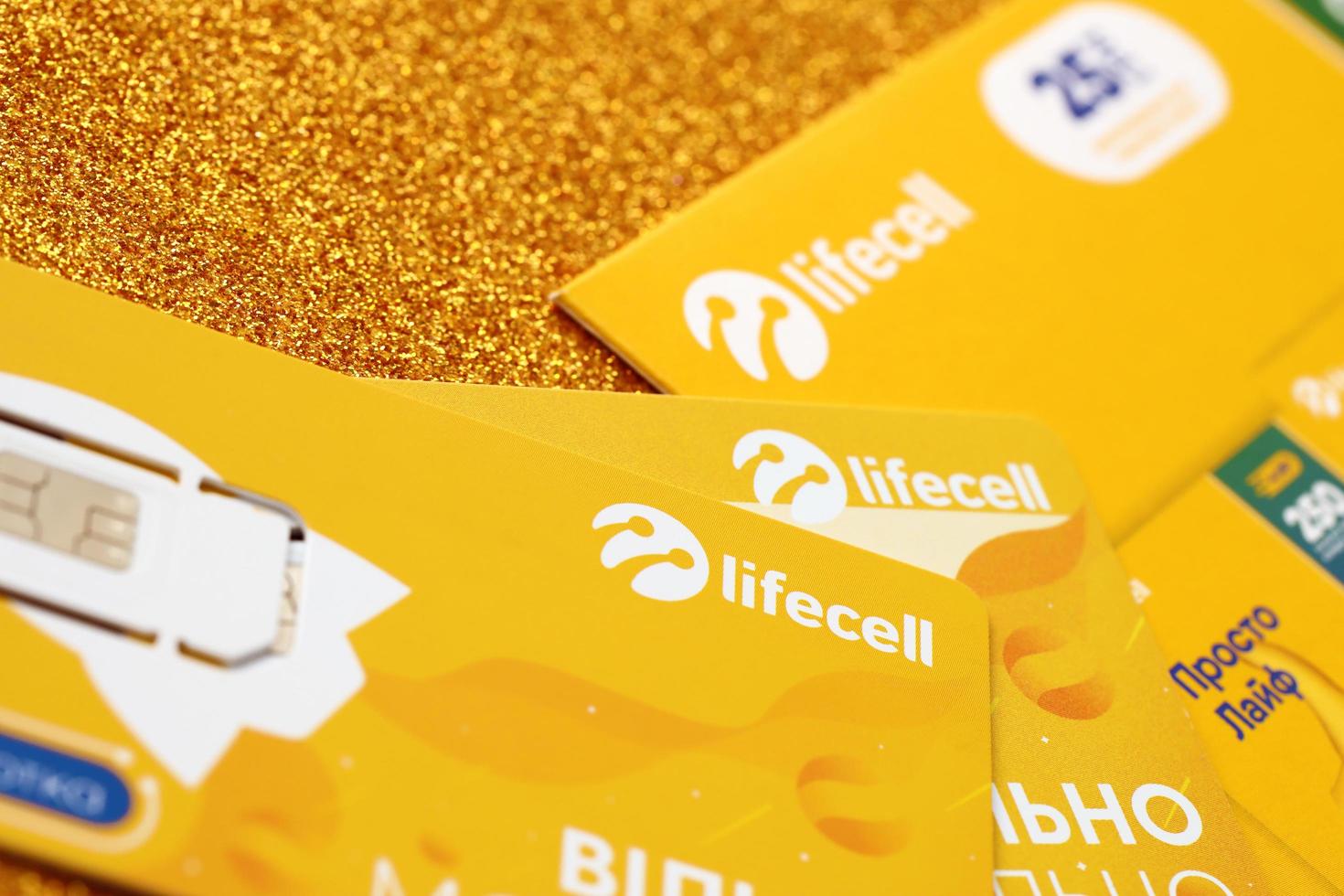 TERNOPIL, UKRAINE - JULY 5, 2022 Lifecell new sim card with free contract on yellow background. Lifecell is ukrainian mobile telephone network operator and provider of wireless connection photo