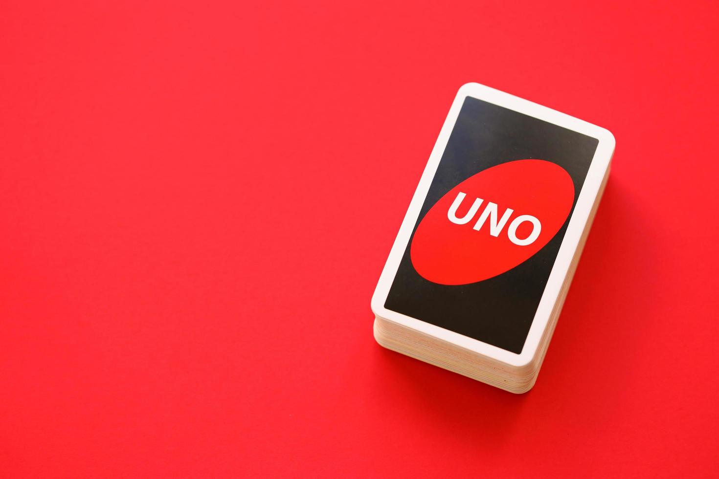 TERNOPIL, UKRAINE - MAY 15, 2022 Many colorful UNO game cards on red background. UNO is an American shedding-type card game that is played with a specially printed deck photo