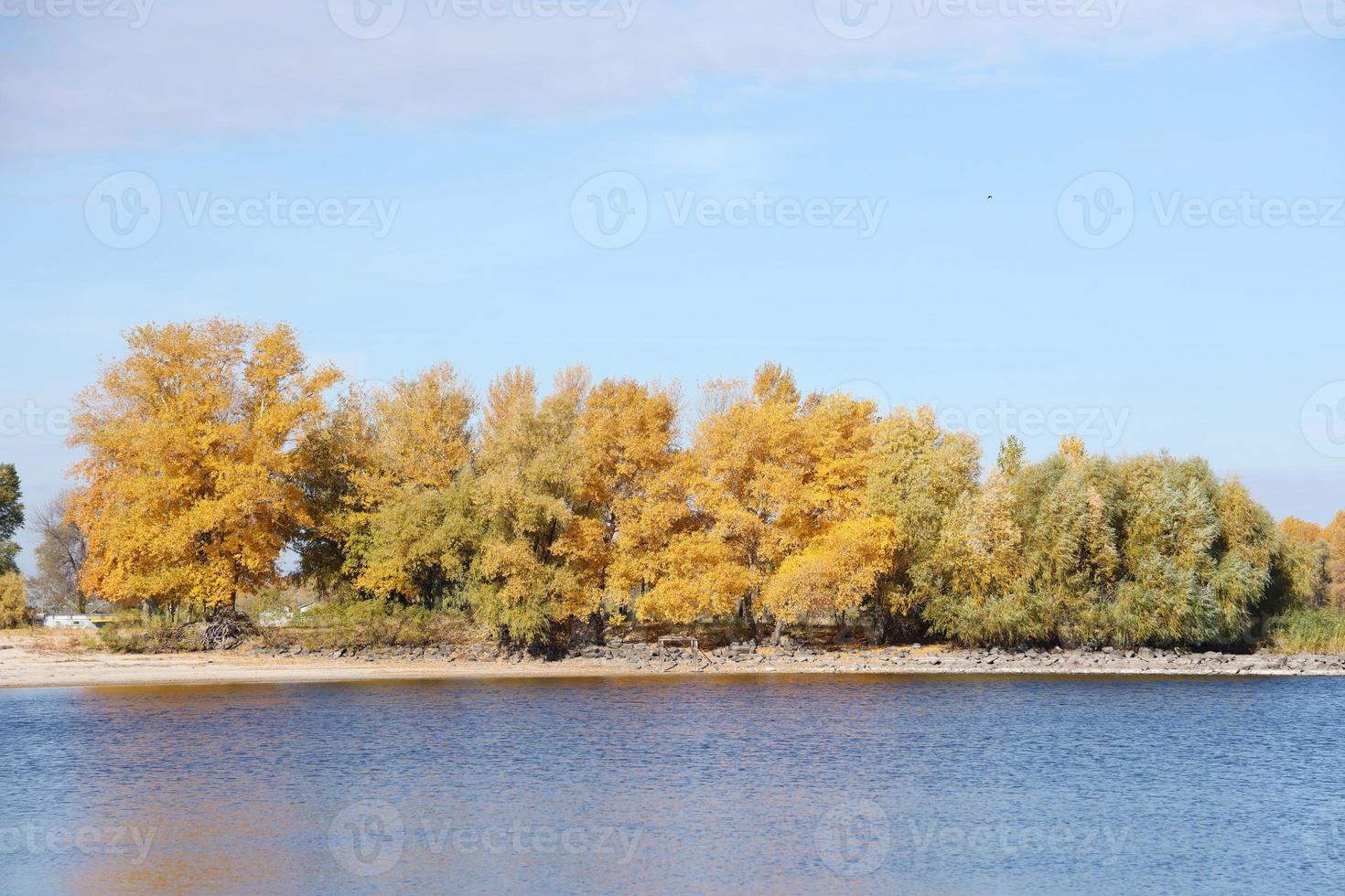 Beautiful autumn landscape with lake and multicoloral trees. Picturesque place with lake and tall trees photo