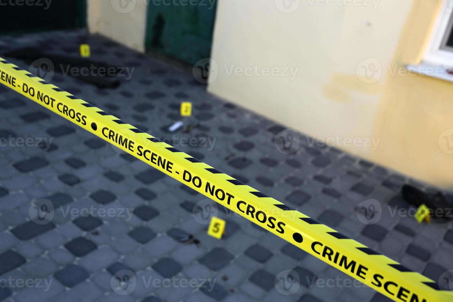 Crime scene tape for covering the area cordon. Yellow tape with blurred forensic law enforcement background in cinematic tone photo