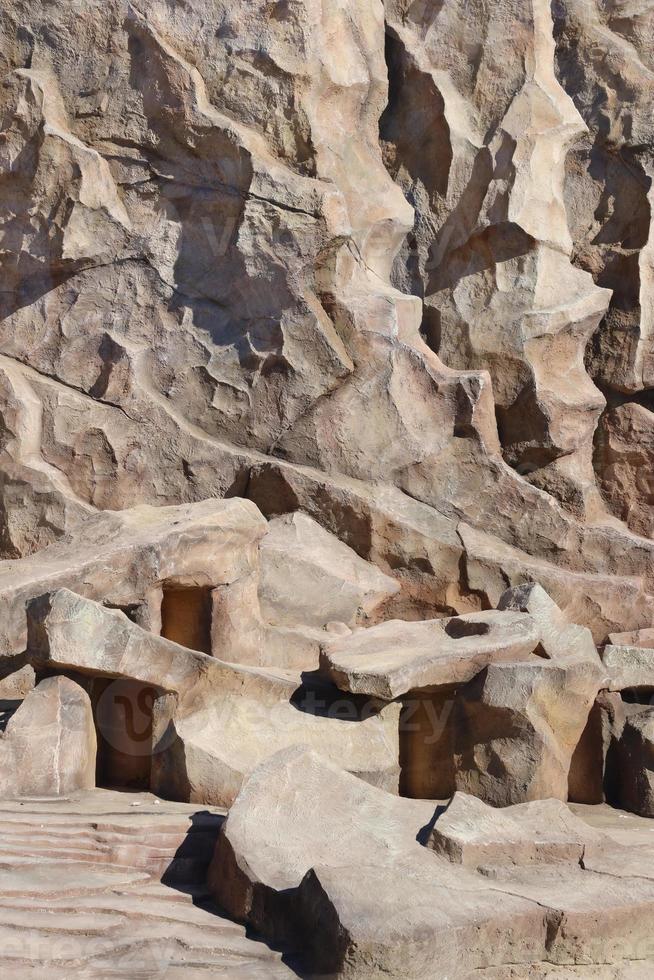 Light coarse natural rock stone background. Mining cliff rough front surface. Big limestone stack backdrop. Heavy grunge damaged granite block texture photo