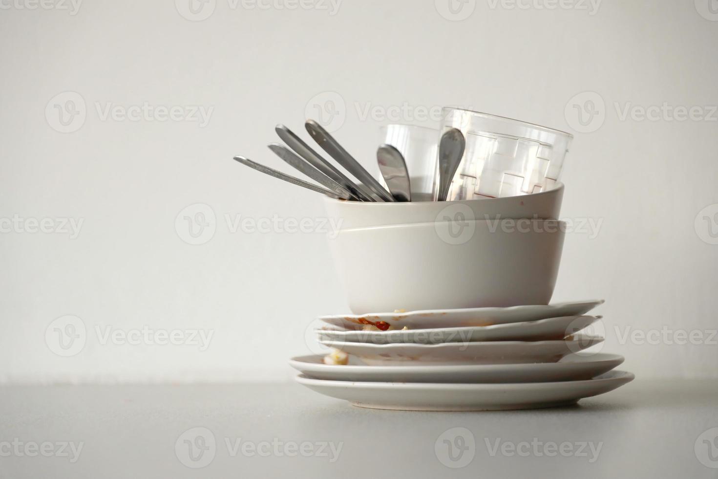 Stack of dirty dishes with food leftovers on the table after meal. Banquet ending concept. Unwashed dishes photo