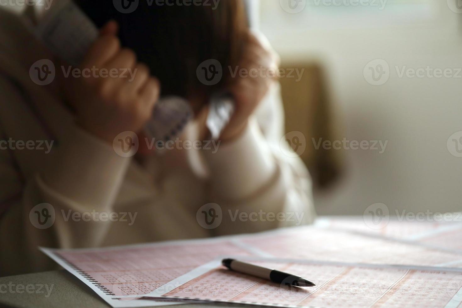 A sad young girl suffers from a loss after looking the unlucky result of the lottery gambling. The concept of losing the lottery and spend money photo