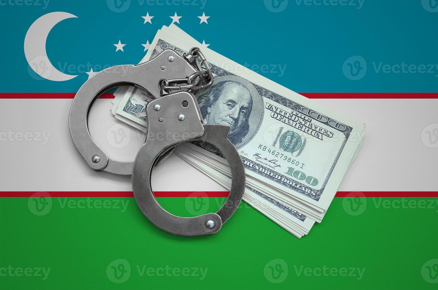 Uzbekistan flag  with handcuffs and a bundle of dollars. Currency corruption in the country. Financial crimes photo