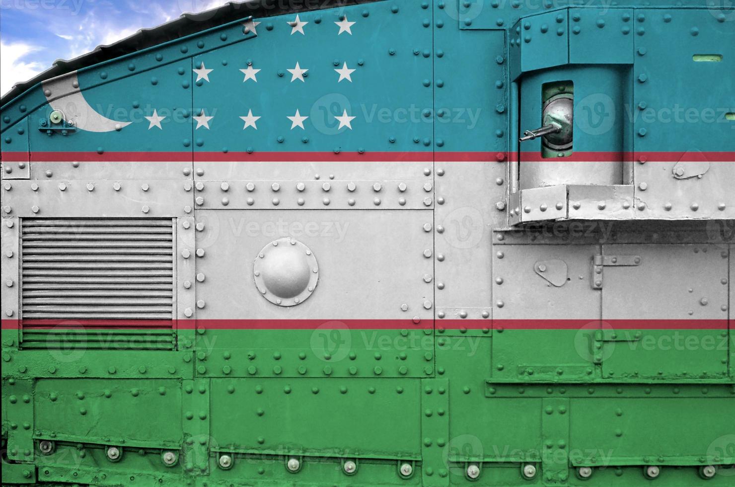 Uzbekistan flag depicted on side part of military armored tank closeup. Army forces conceptual background photo