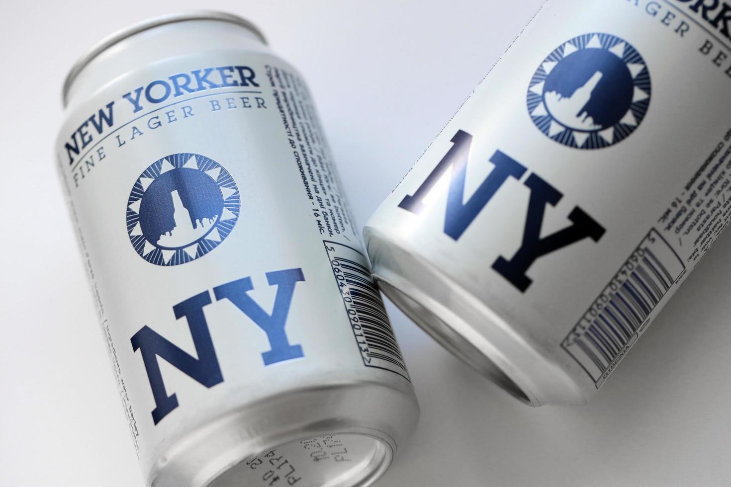 TERNOPIL, UKRAINE - JULY 18, 2022 Two cans of New Yorker fine lager beer with original logo and design on white paper background photo