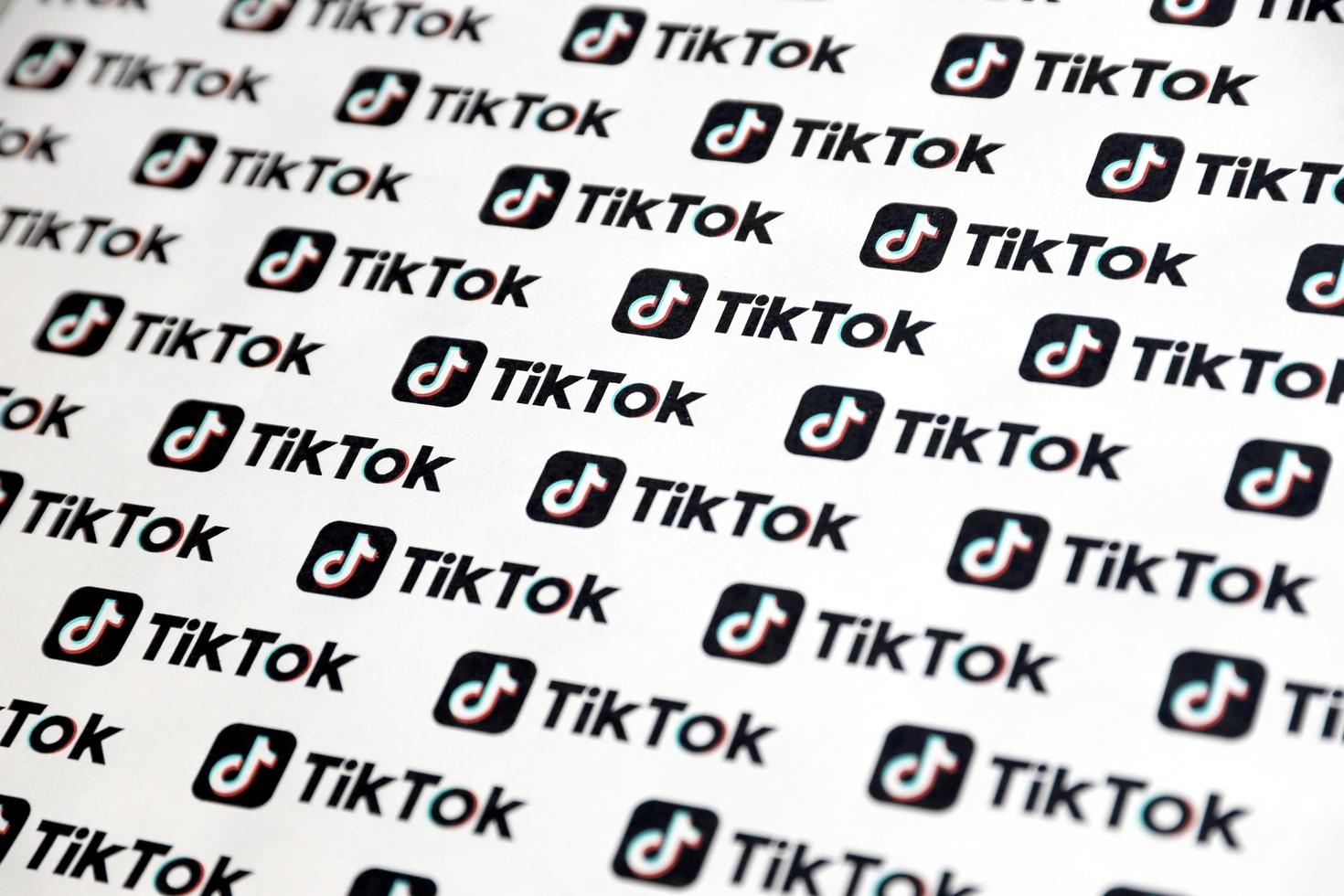 TERNOPIL, UKRAINE - MAY 2, 2022 Many TikTok logo printed on paper. Tiktok or Douyin is a famous Chinese short-form video hosting service owned by ByteDance photo