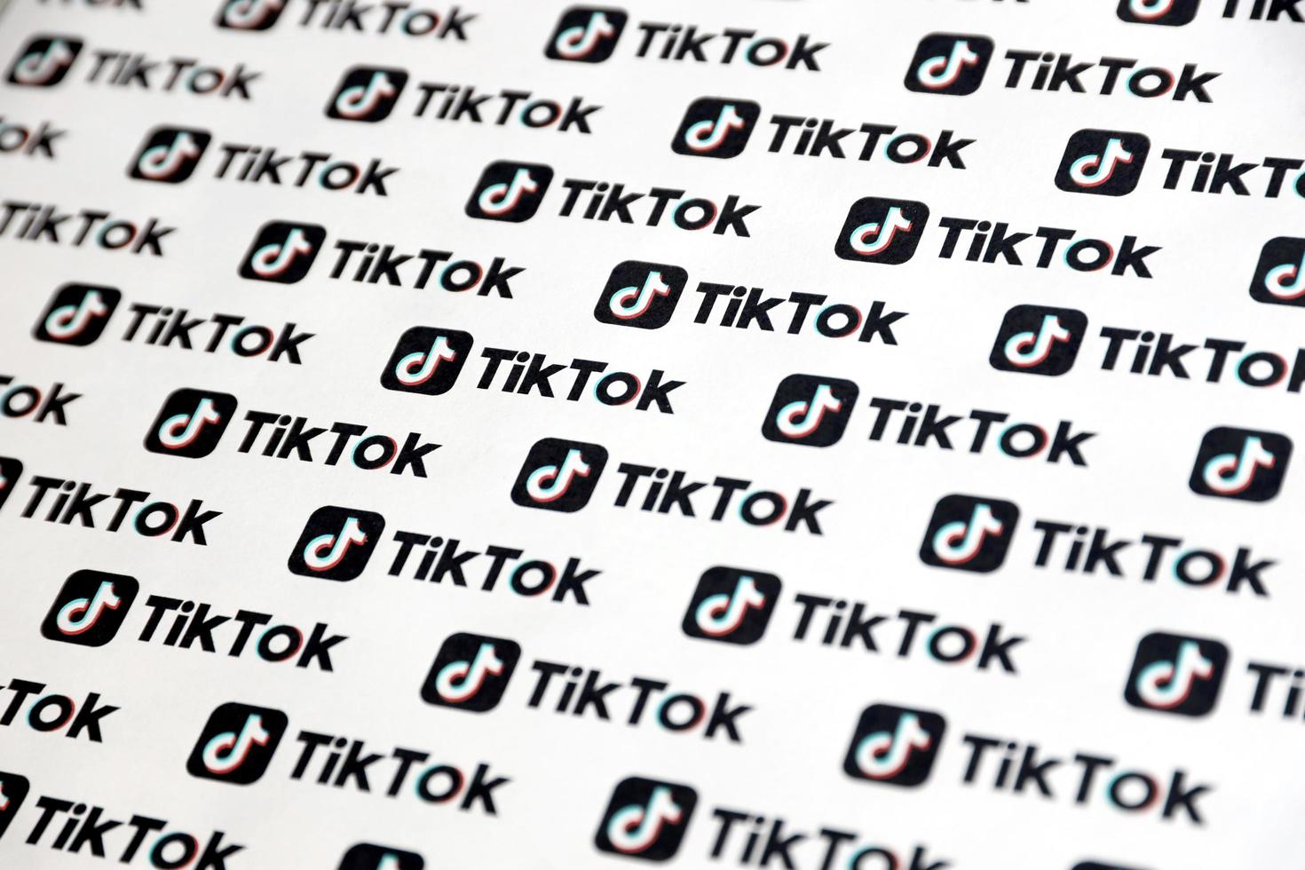 ternopil, ucrania - 2 de mayo de 2022 muchos logotipos de tiktok impresos en papel. tiktok o douyin es un famoso servicio chino de alojamiento de videos de formato corto propiedad de bytedance foto