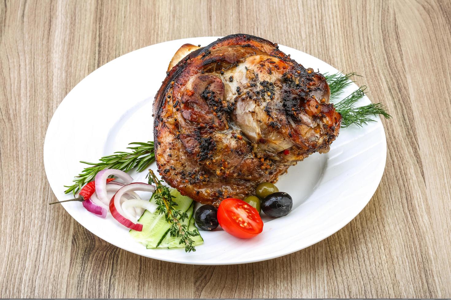 Pork knee on the plate and wooden background photo