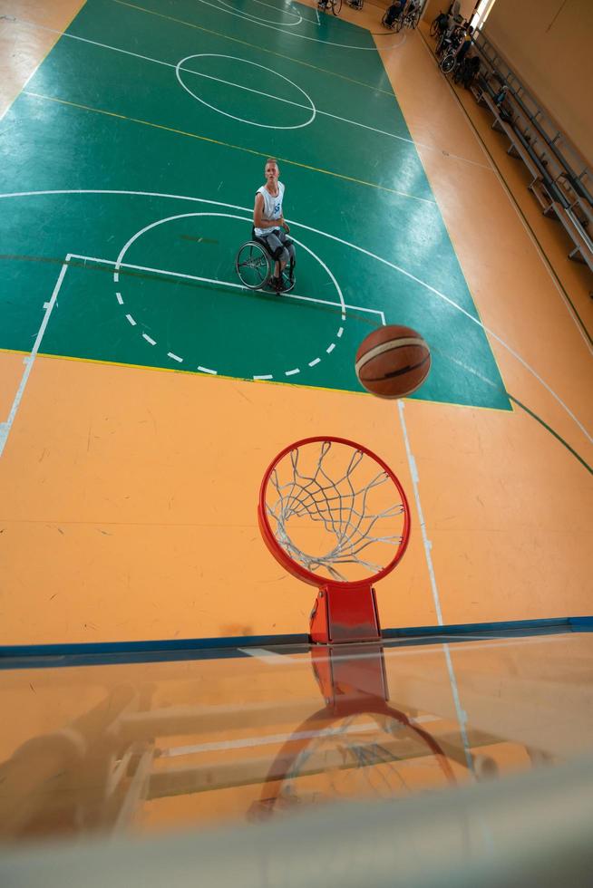 tow view photo of a war veteran playing basketball in a modern sports arena. The concept of sport for people with disabilities