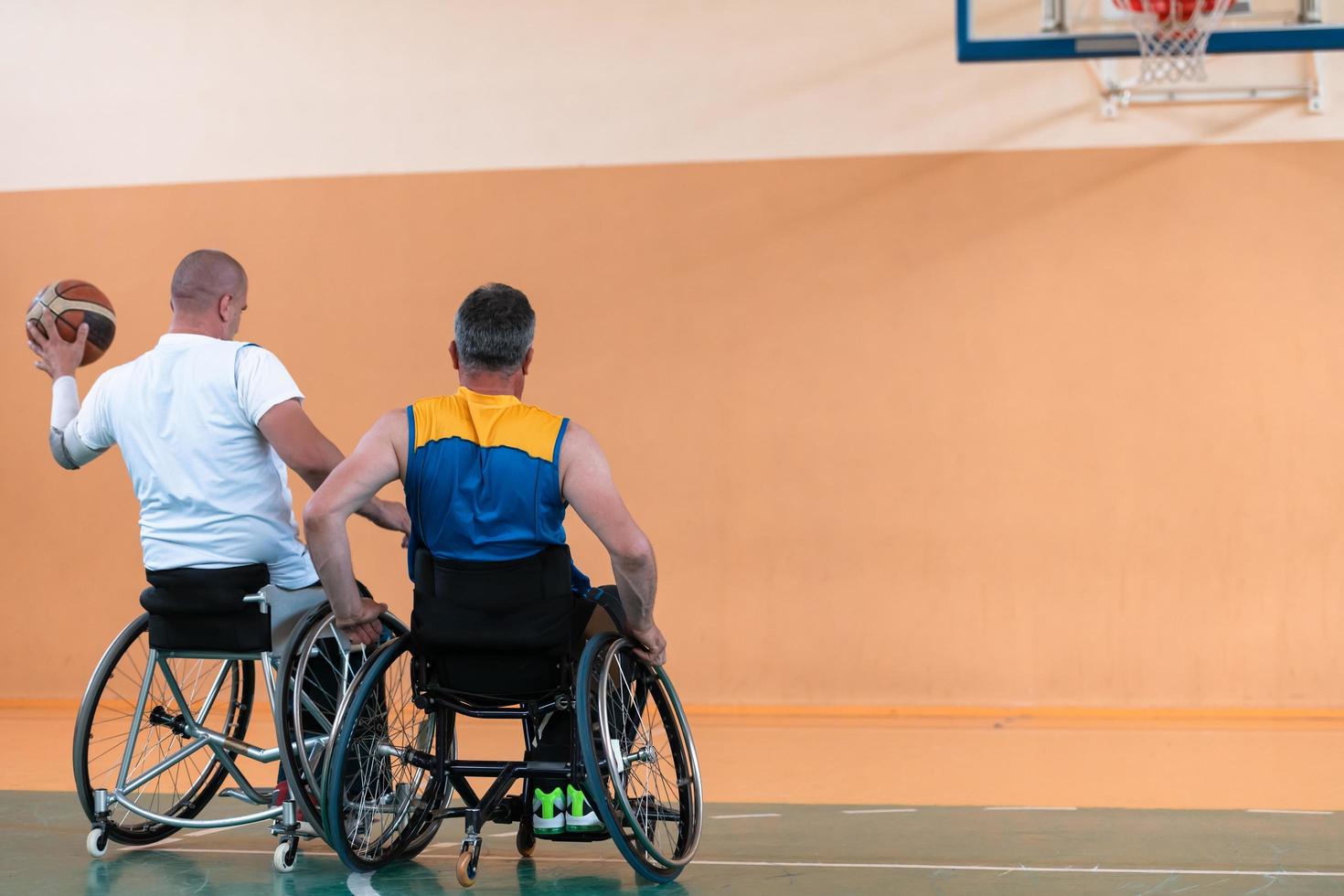 una foto de un veterano de guerra jugando baloncesto con un equipo en un estadio deportivo moderno. el concepto de deporte para personas con discapacidad