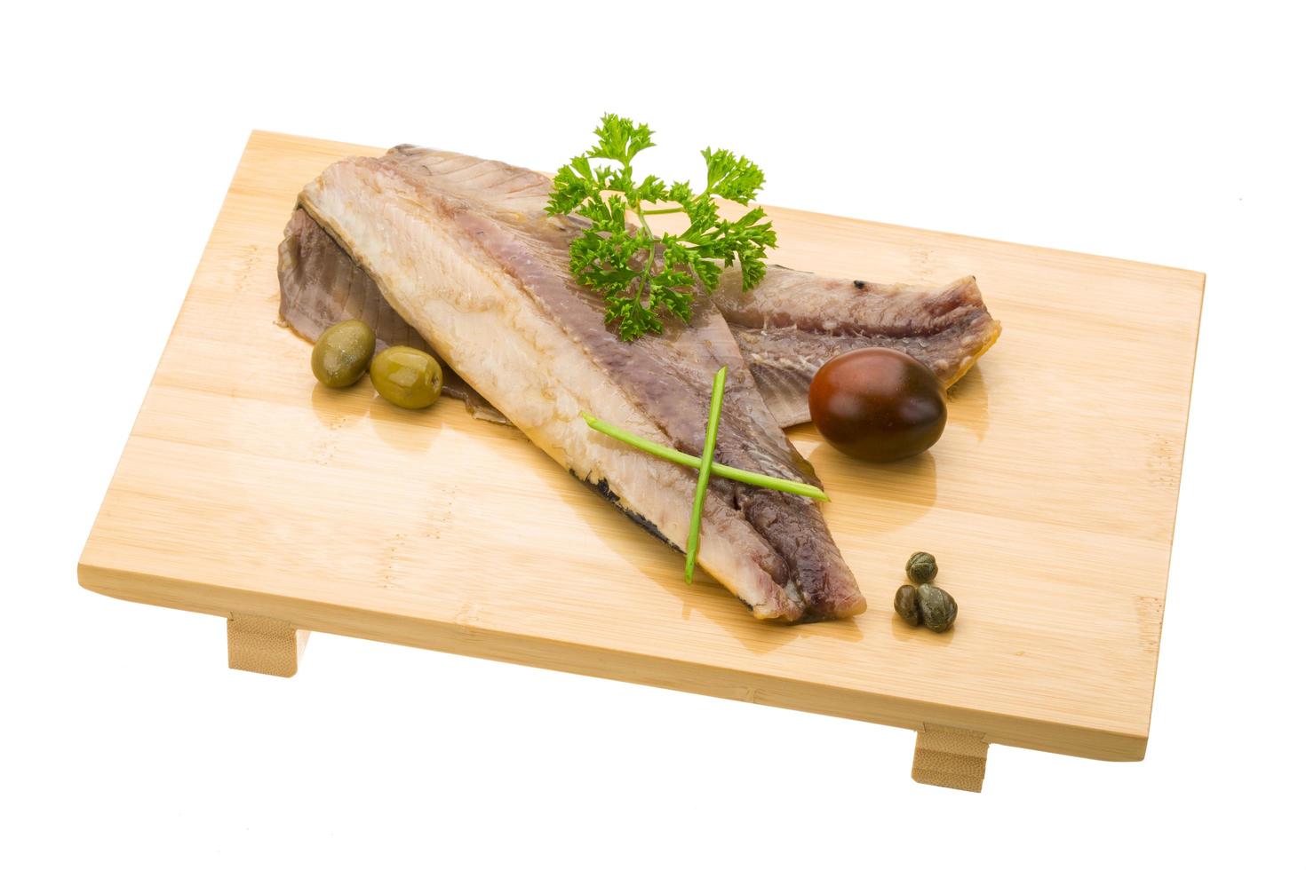 Herring on wooden board and white background photo