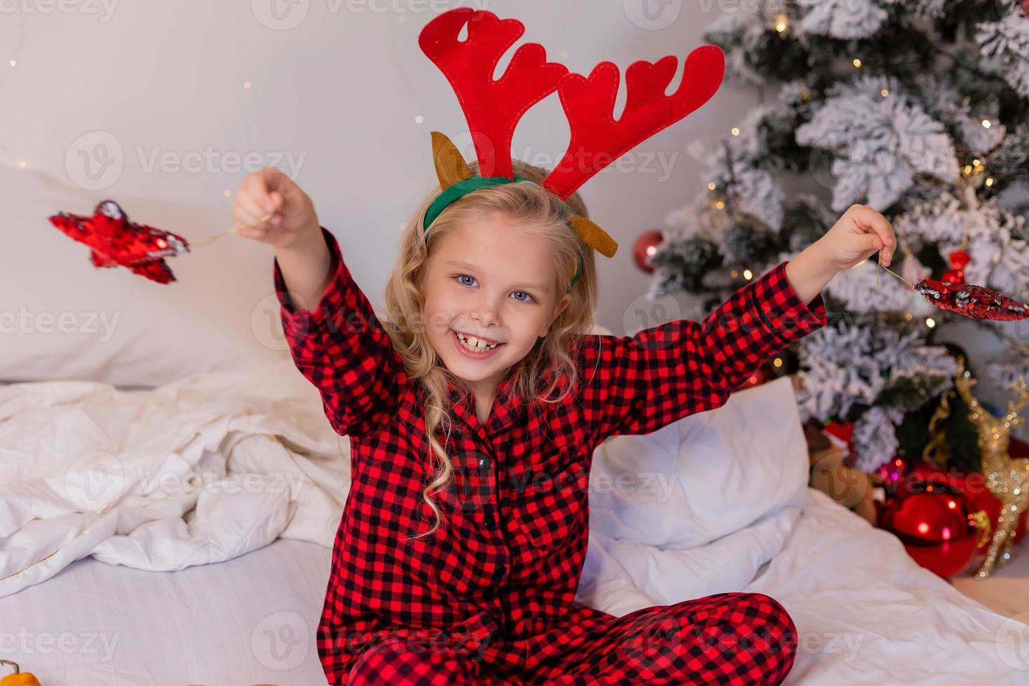 televisor Mansión Nota niña rubia feliz en casa en pijama para Navidad clasificando regalos y  jugando con juguetes de Navidad 12890685 Foto de stock en Vecteezy