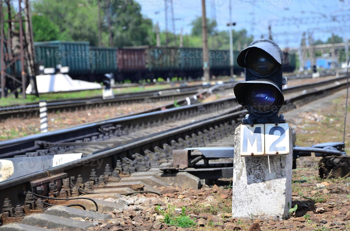 Railway traffic light semaphore against the background of a day railway landscape. Signal device on the railway track photo