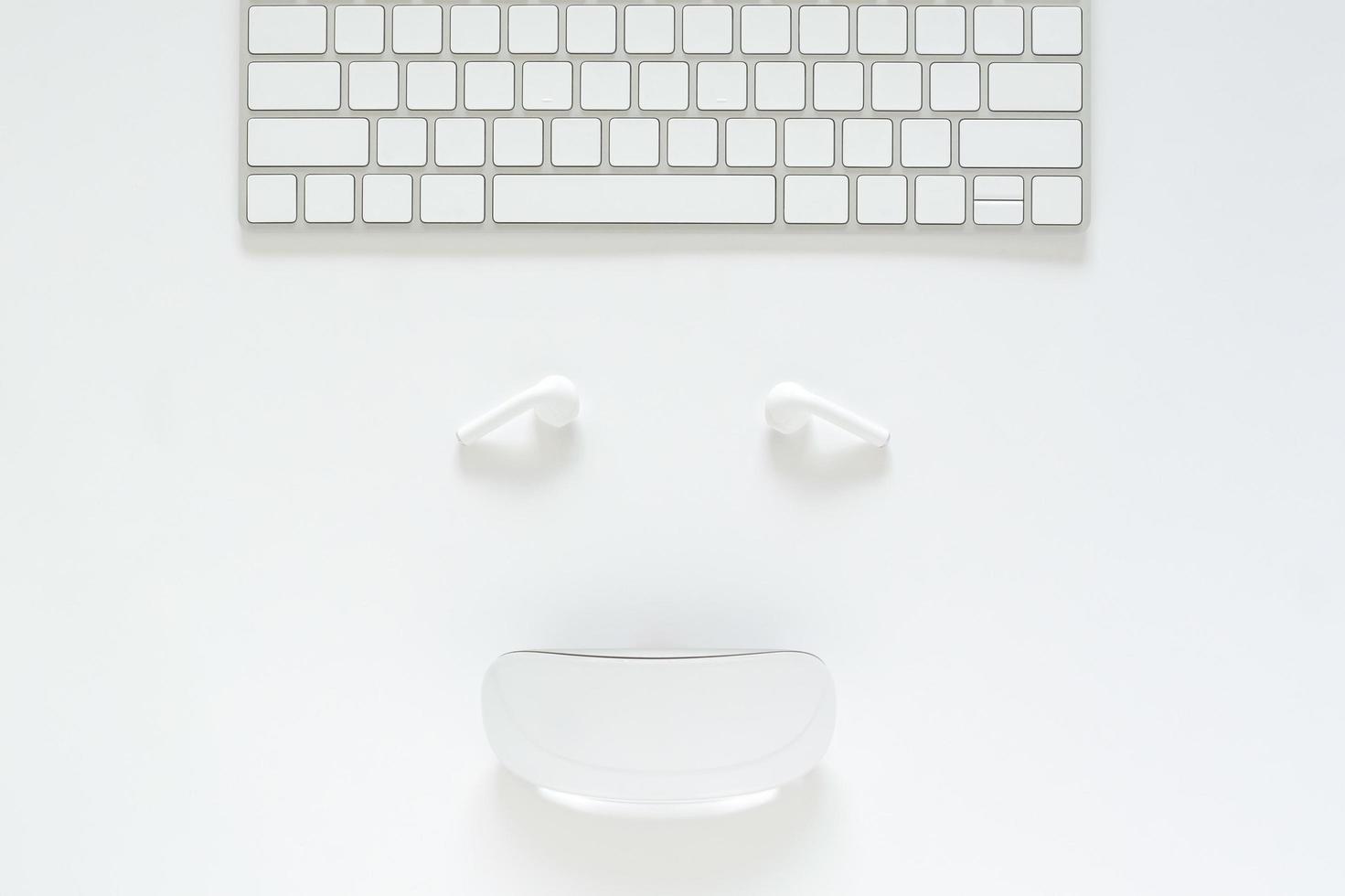 disposición plana de teclado, auricular y mouse configurados como cara sonriente sobre fondo blanco para el concepto de venta en línea del lunes cibernético. foto