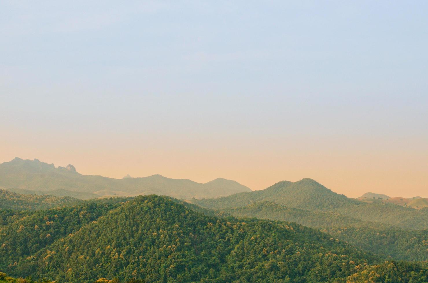 The morning scene with sunlight shining on the landscape of mountain with forest in rural area at the north of Thailand. photo