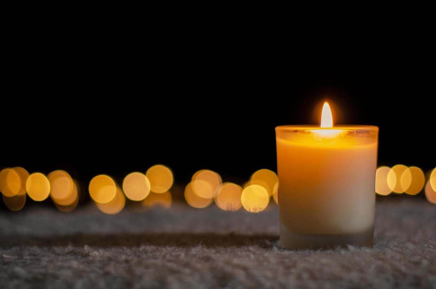 Candle lights in darkness with golden bokeh lights for Christmas and New year concept. photo