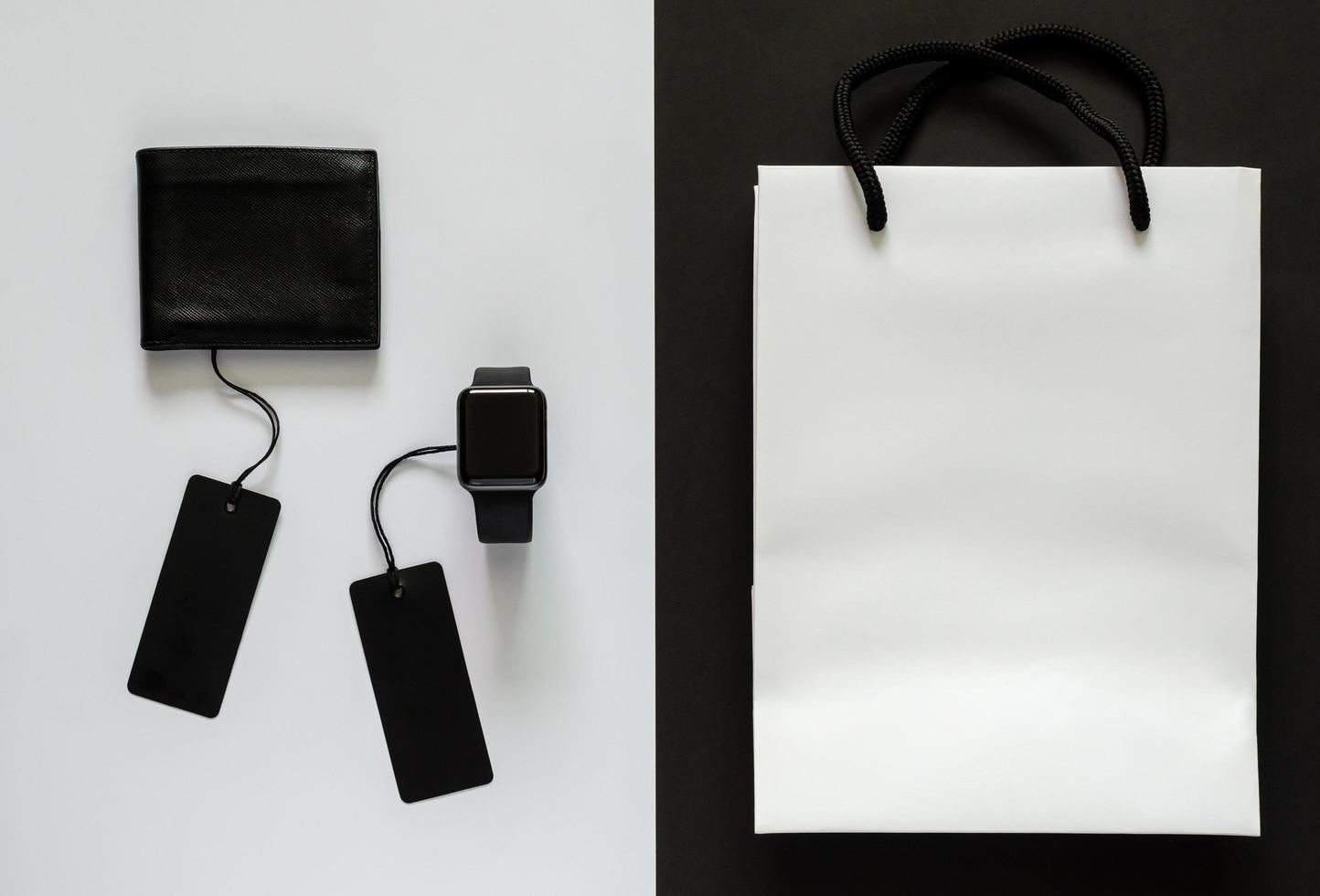 Black price tags with merchandise and white shopping bag on white and black background. Black Friday concept. photo