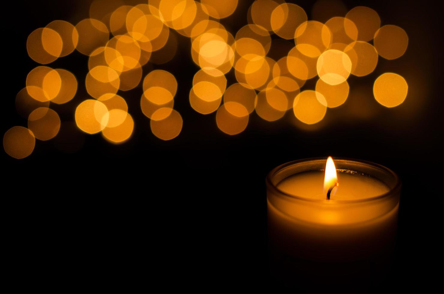Aromatic candle with flame and round shape bokeh on dark background for Thanks giving and Christmas day. photo
