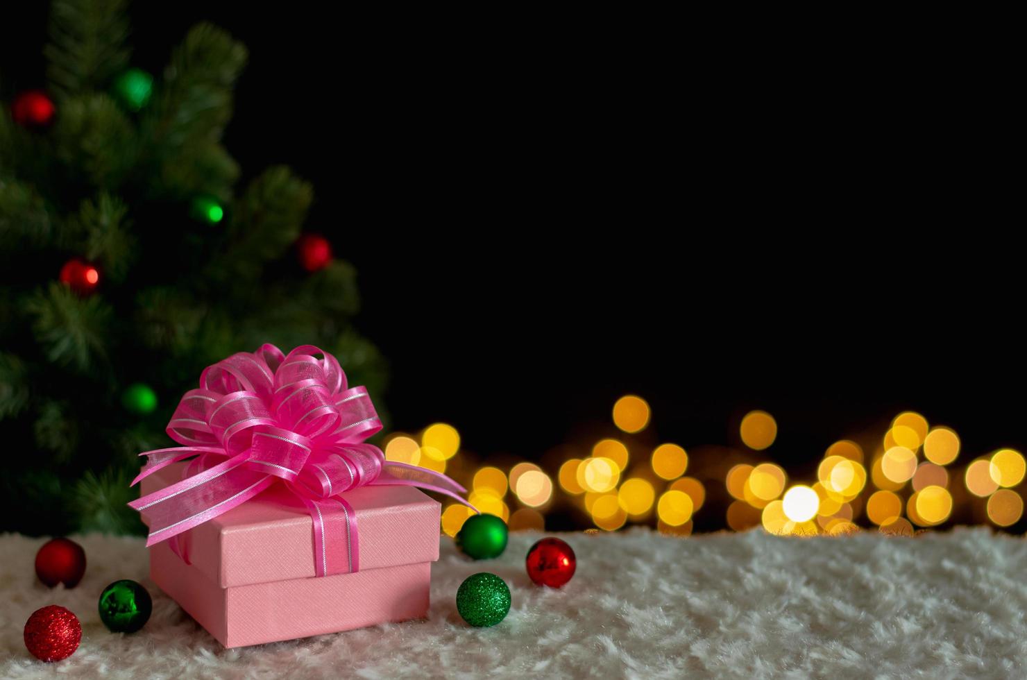 Gift box and ornaments with Christmas tree and lights background. Christmas and New year concept. photo