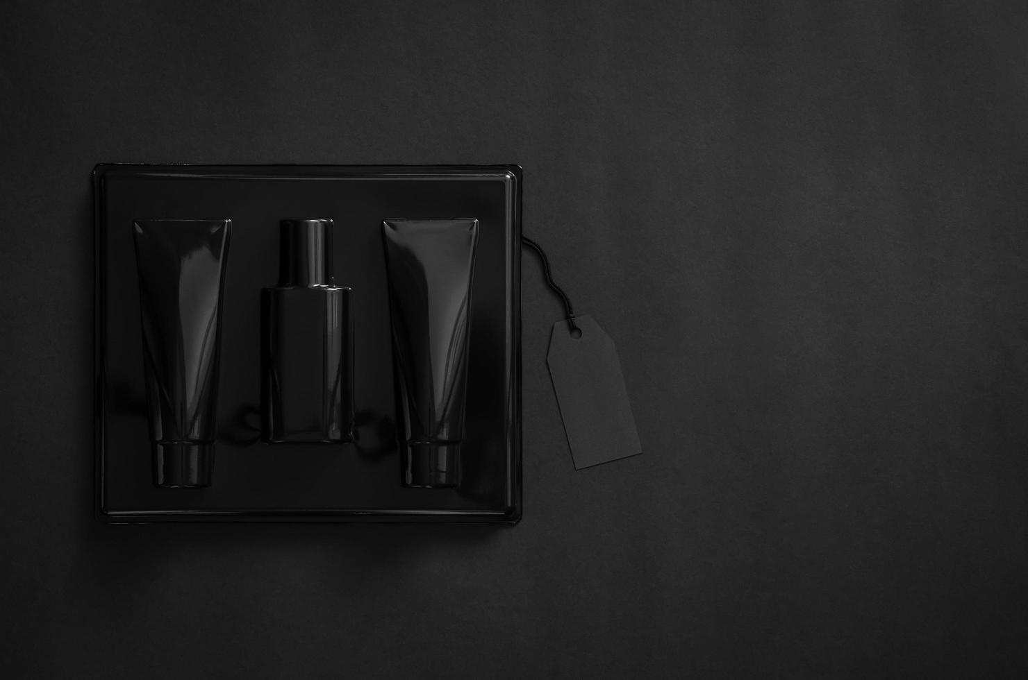 A black box of perfume with blank black price tag on black background. Black Friday concept. photo