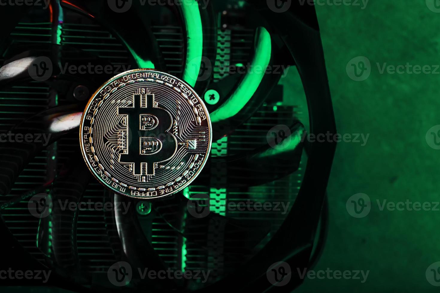 Gold bitcoin on the video card cooler with green neon lighting in the Cyberpunk style. photo