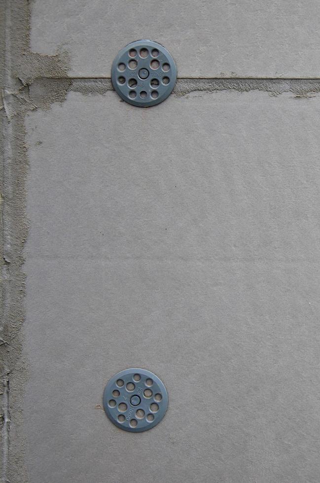 The texture of the wall, covered with gray foam polystyrene plates, which are reinforced with plastic umbrella dowels. Stage of wall insulation photo