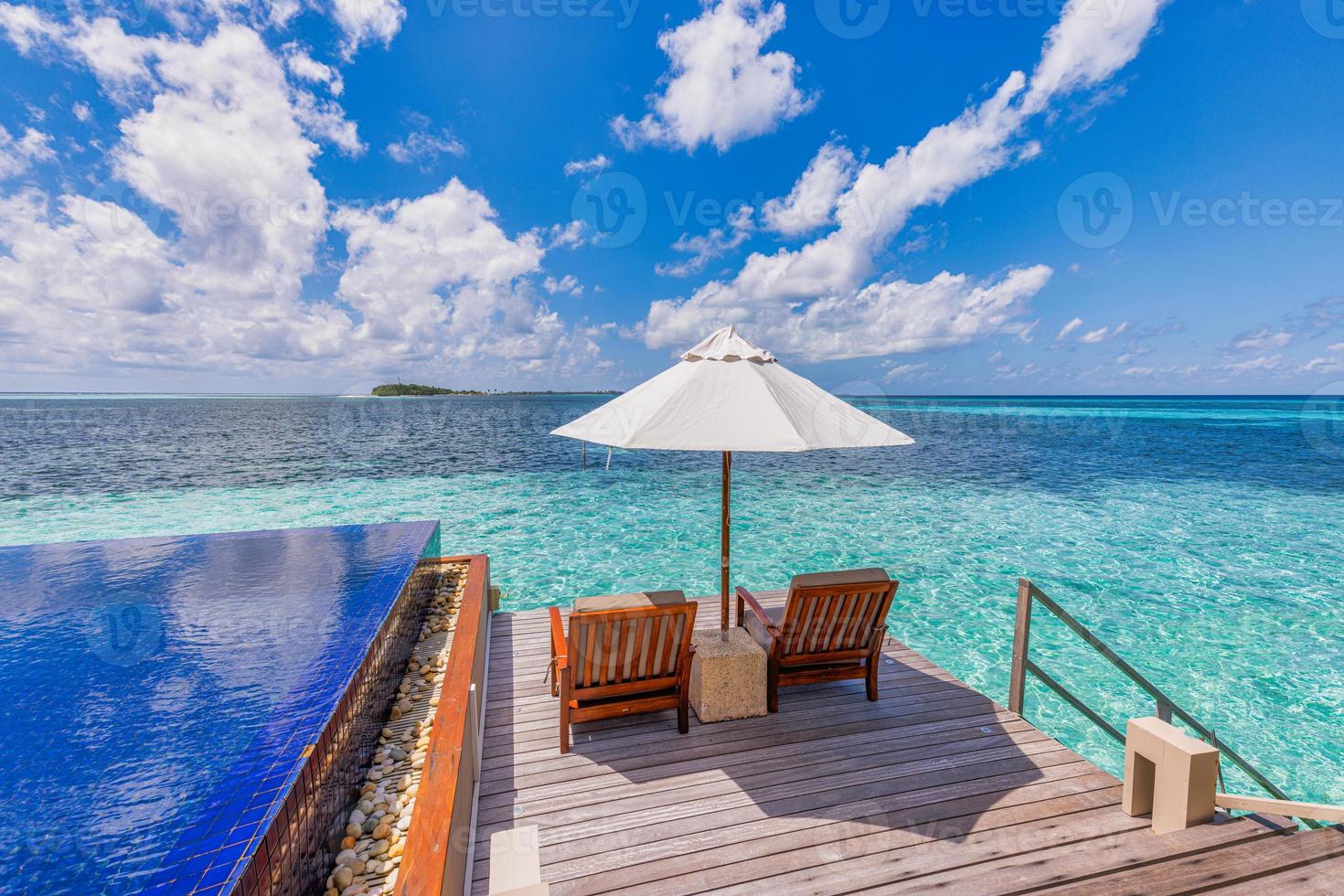 Beautiful panoramic travel sea landscape, luxury romantic beach holidays for honeymoon couple, tropical vacation in luxurious hotel resort. Amazing water villa with chairs and umbrella, infinity pool photo