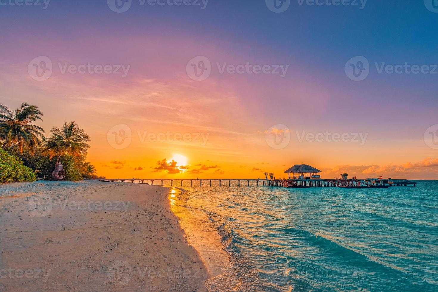 Fantastic closeup view of sunset beach. Tropical island beach landscape exotic palm coast, wooden pier. Summer romantic vacation, holiday amazing nature scenic. Relax paradise, beautiful sunrise sky photo