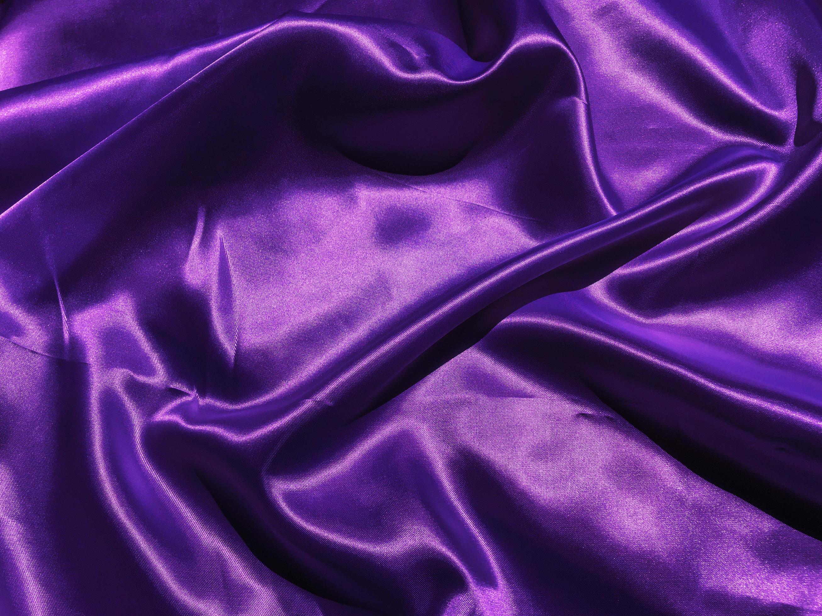 Closeup of purple satin or silk texture background. Copy space with
