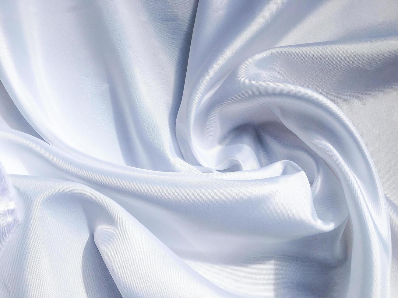 white crumpled fabric texture background. Silk curtain with fold waves for design photo