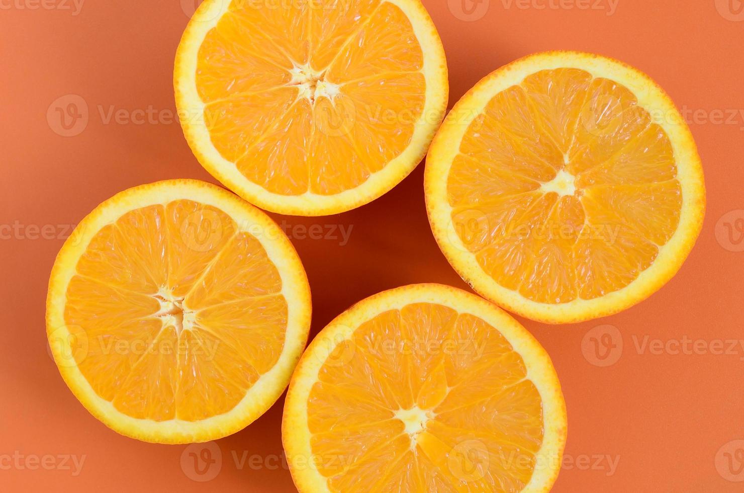 Top view of a several orange fruit slices on bright background in orange color. A saturated citrus texture image photo