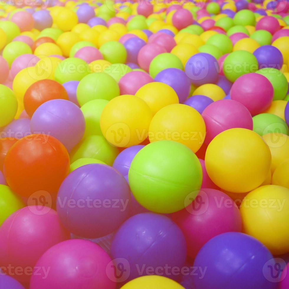Many colorful plastic balls in a kids' ballpit at a playground. Close up pattern photo