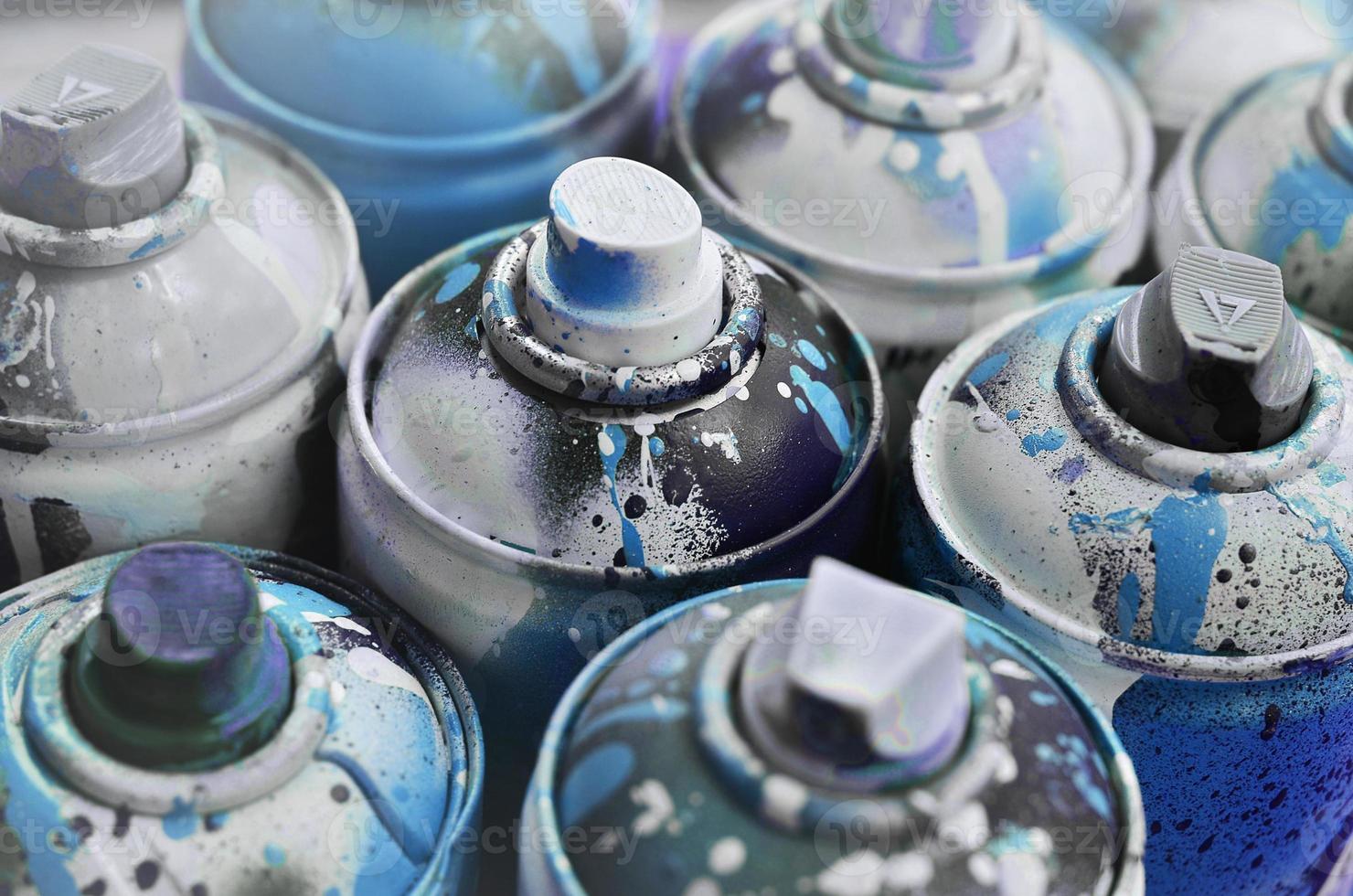 A lot of used spray cans of paint close-up. Dirty and smeared cans for drawing graffiti. The concept of a sweeping and careless drawing of paint. Creative art image photo