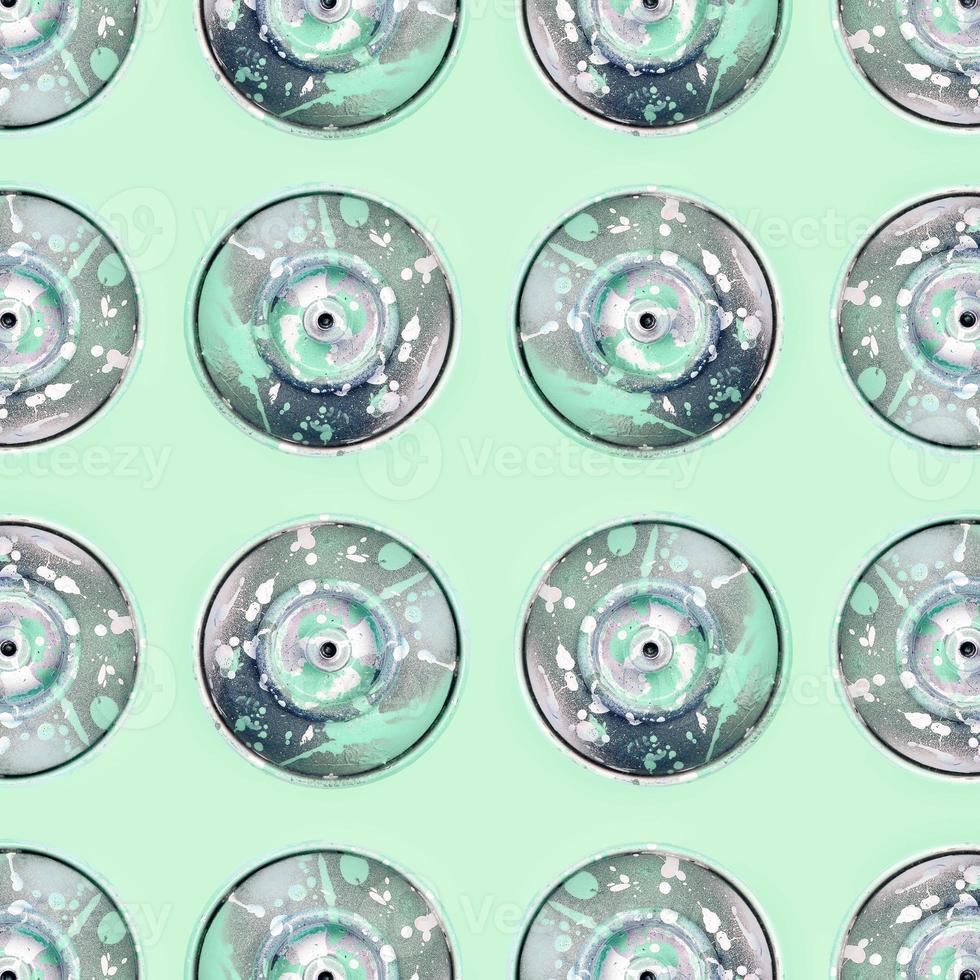 Many used spray cans for graffiti drawing lies on a pastel colored backgroung. Street art painting concept. Minimal flat lay pattern. Top view photo