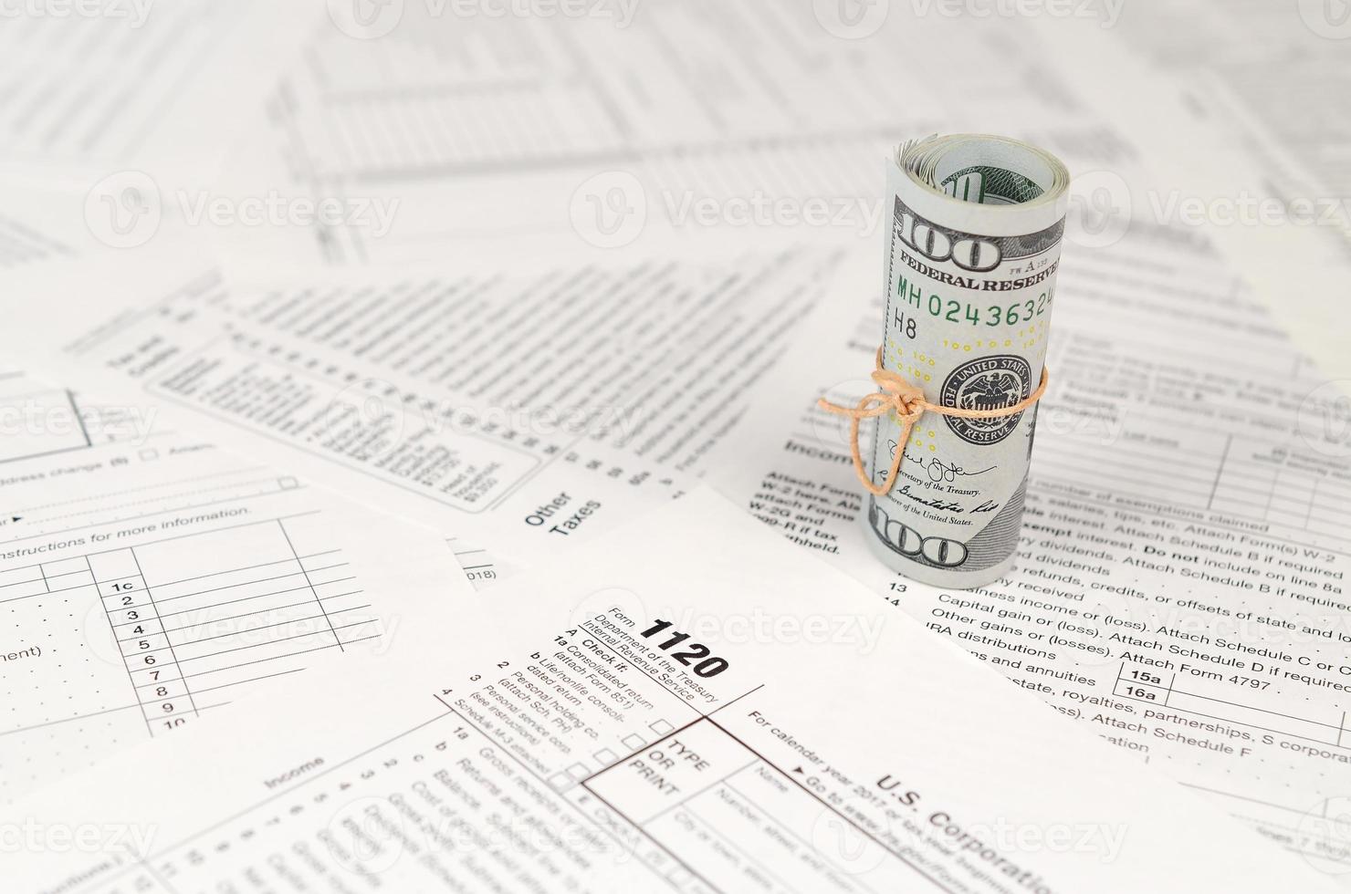 1120 U.S. Corporation income tax return form with roll of american dollar banknotes photo