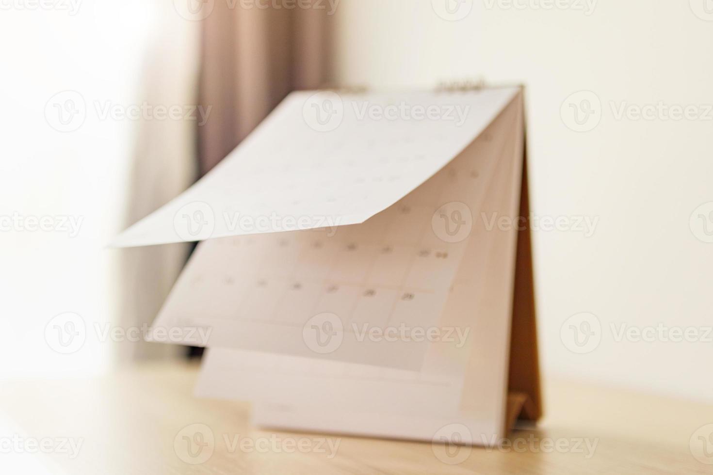 Blur Calendar page flipping sheet on wood table background business schedule planning appointment meeting concept photo