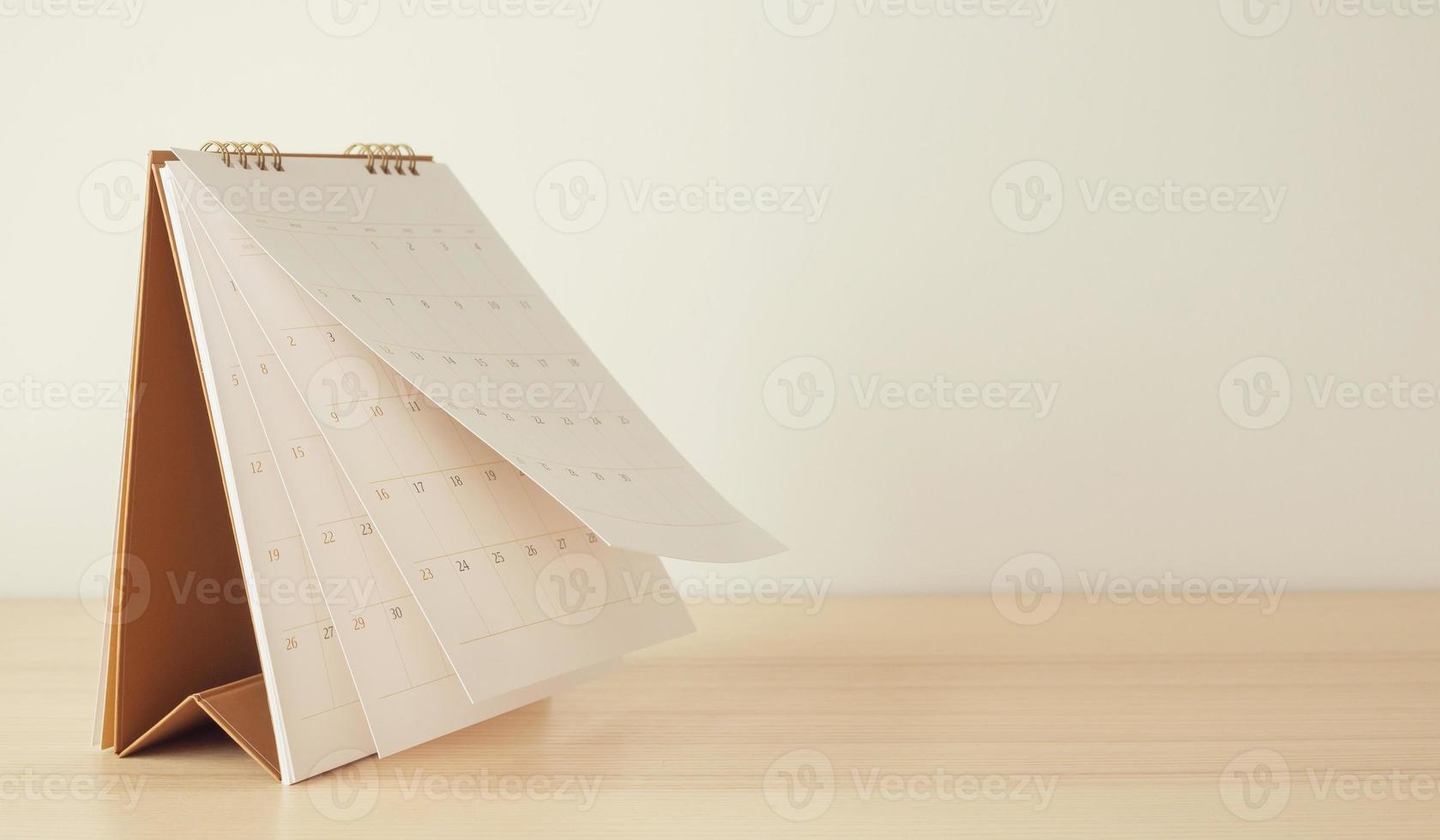 Calendar page flipping sheet on wood table background business schedule planning appointment meeting concept photo