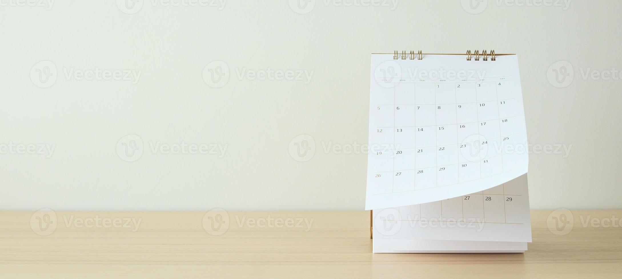 Calendar page flipping sheet on wood table background business schedule planning appointment meeting concept photo