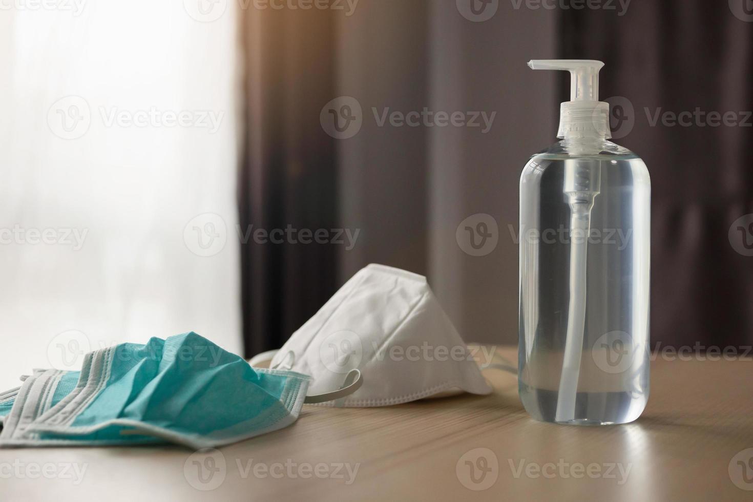 Medical face mask with alcohol sanitizer gel hand wash on wood table for covid-19 Coronavirus prevention concept photo