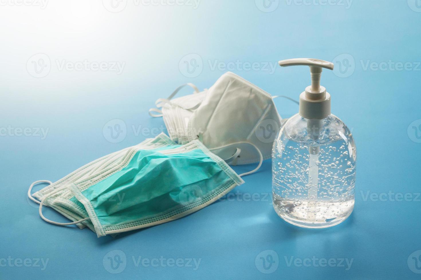 Alcohol sanitizer gel hand wash bottle with N95 Medical face mask on blue background covid-19 Coronavirus prevention concept photo