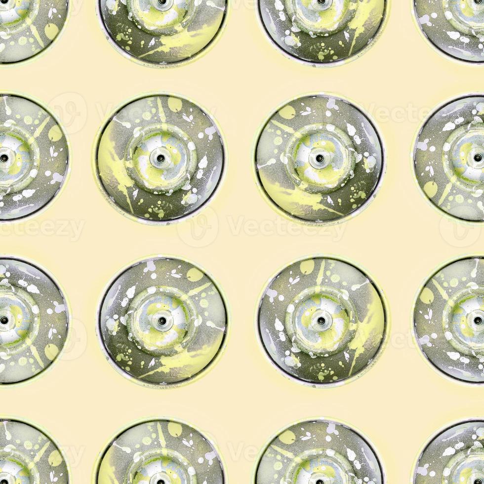 Many used spray cans for graffiti drawing lies on a pastel colored backgroung. Street art painting concept. Minimal flat lay pattern. Top view photo