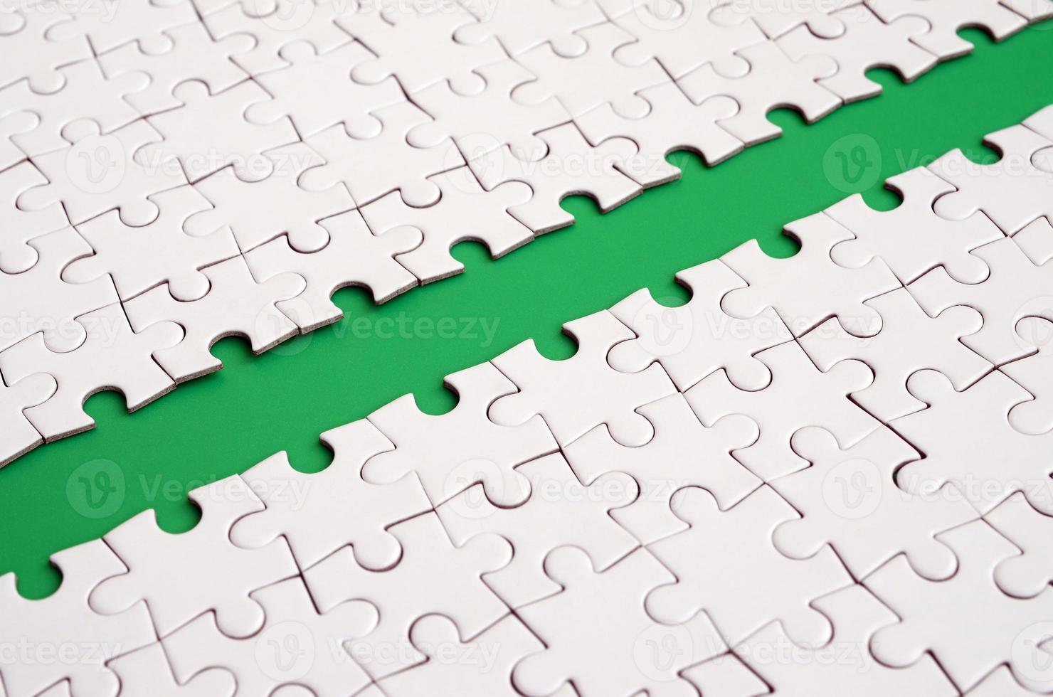 The green path is laid on the platform of a white folded jigsaw puzzle. Texture image with copy space for text photo