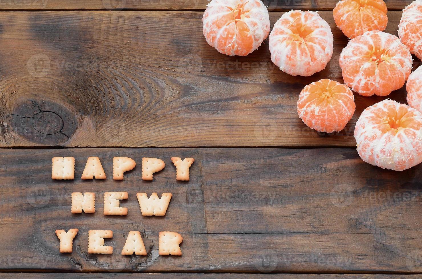 Tangerines, cracker text with copy space on wooden background photo