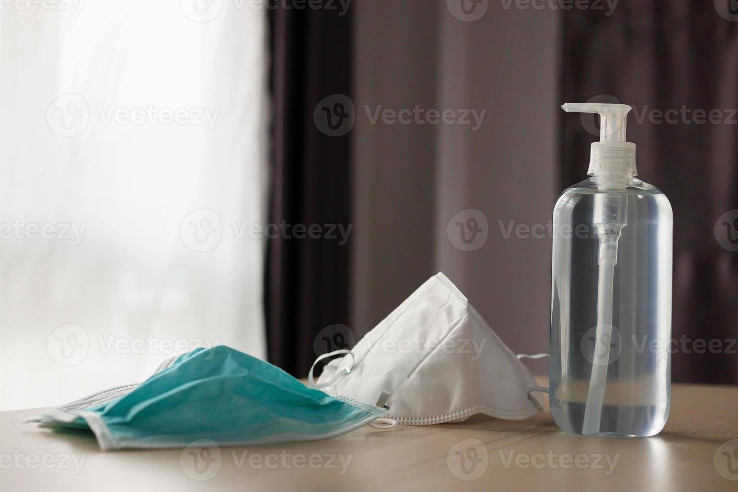 mascarilla médica con gel desinfectante de alcohol lavado a mano en mesa de madera para el concepto de prevención del coronavirus covid-19 foto