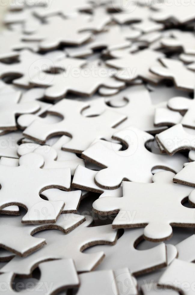 Close-up of a pile of uncompleted elements of a white puzzle. A huge number of rectangular pieces from one large white mosaic photo