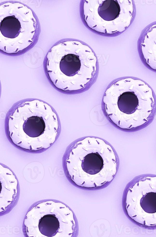 Many small plastic donuts lies on a pastel colorful background. Flat lay minimal pattern. Top view photo