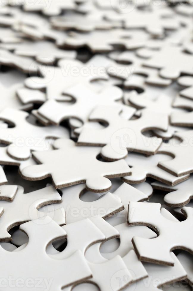 Close-up of a pile of uncompleted elements of a white puzzle. A huge number of rectangular pieces from one large white mosaic photo