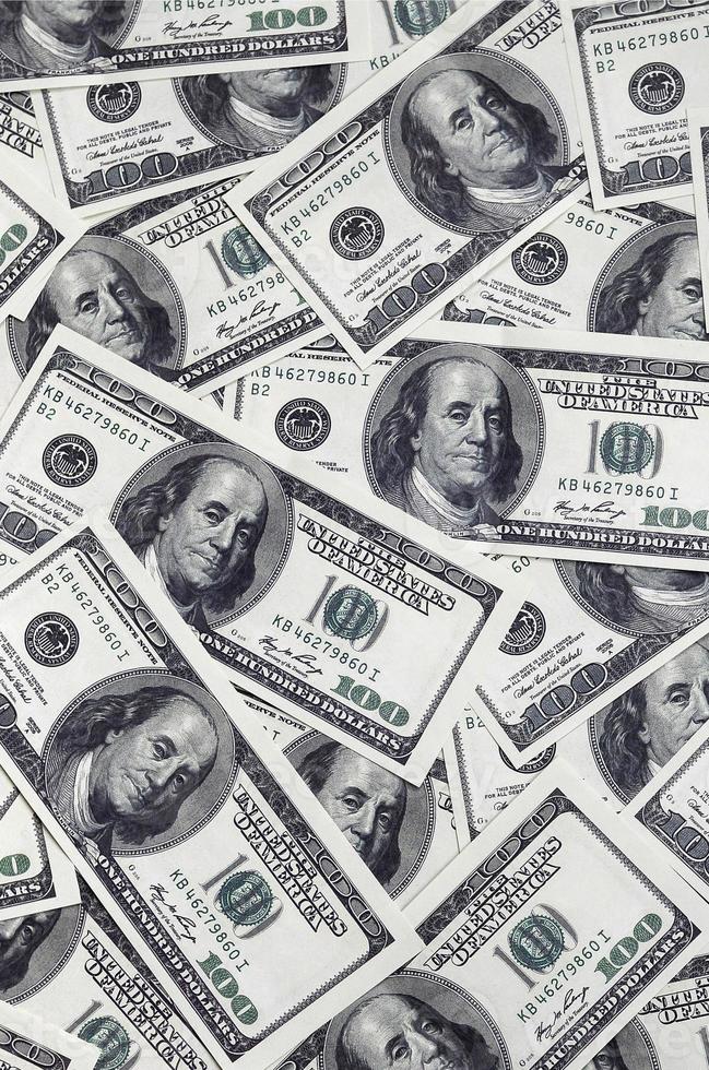 A pile of one hundred US banknotes with president portraits. Cash of hundred dollar bills, dollar background image with high resolution photo