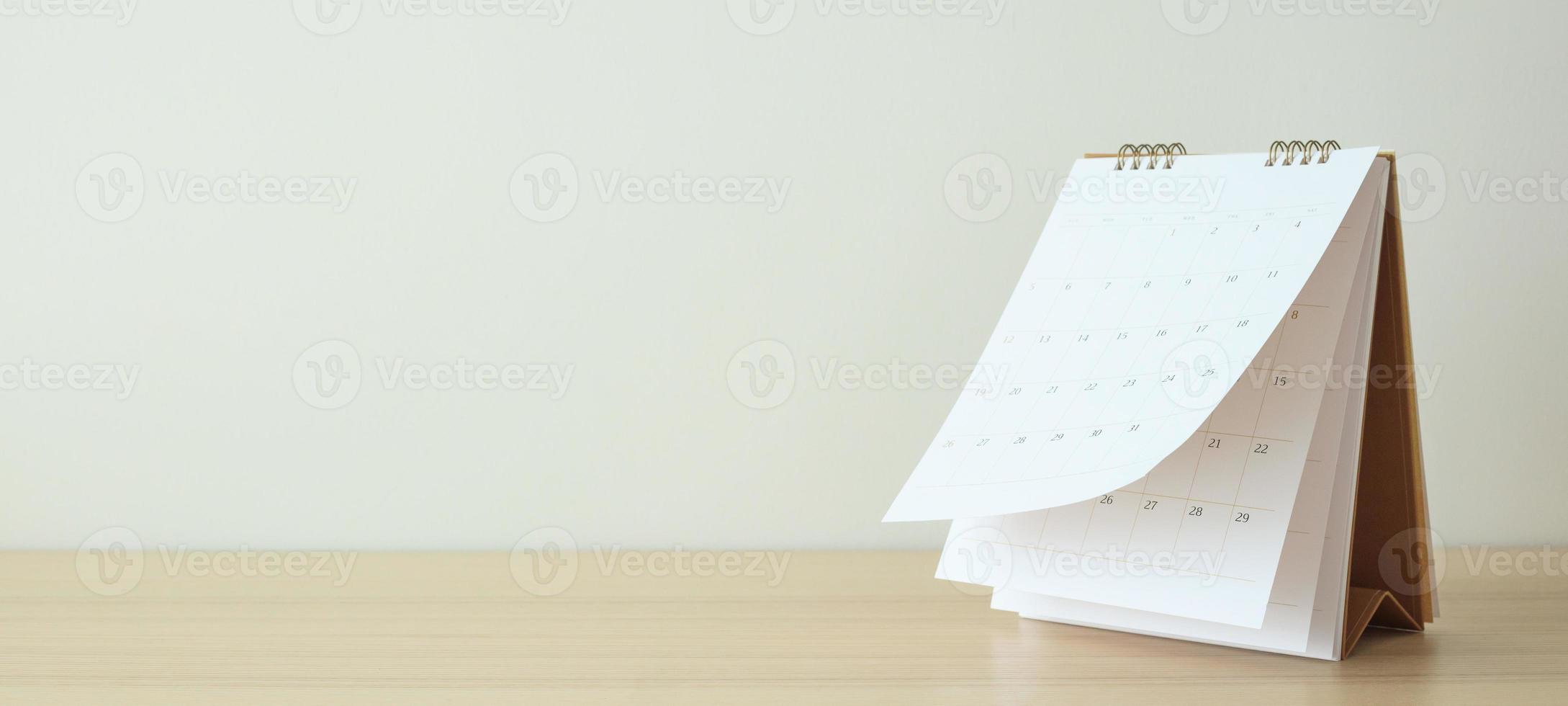 Calendar page flipping sheet on wood table background business schedule planning appointment meeting concept photo